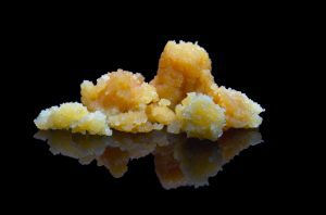 cannabis concentrate sugar on black surface