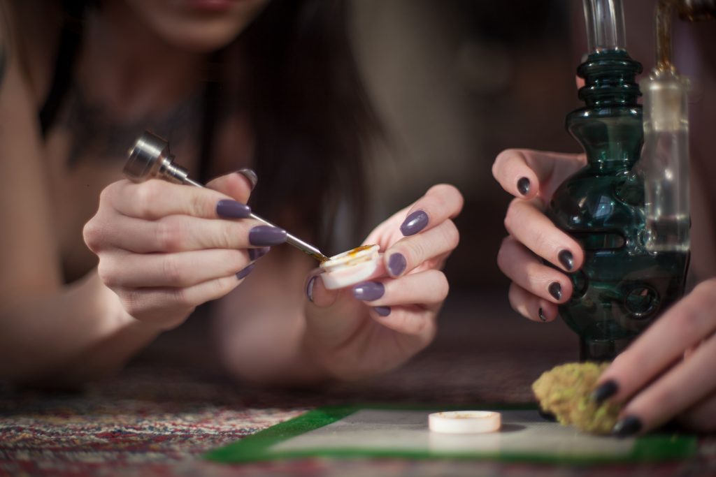 person preparing a dab rig to smoke cannabis concentrates 